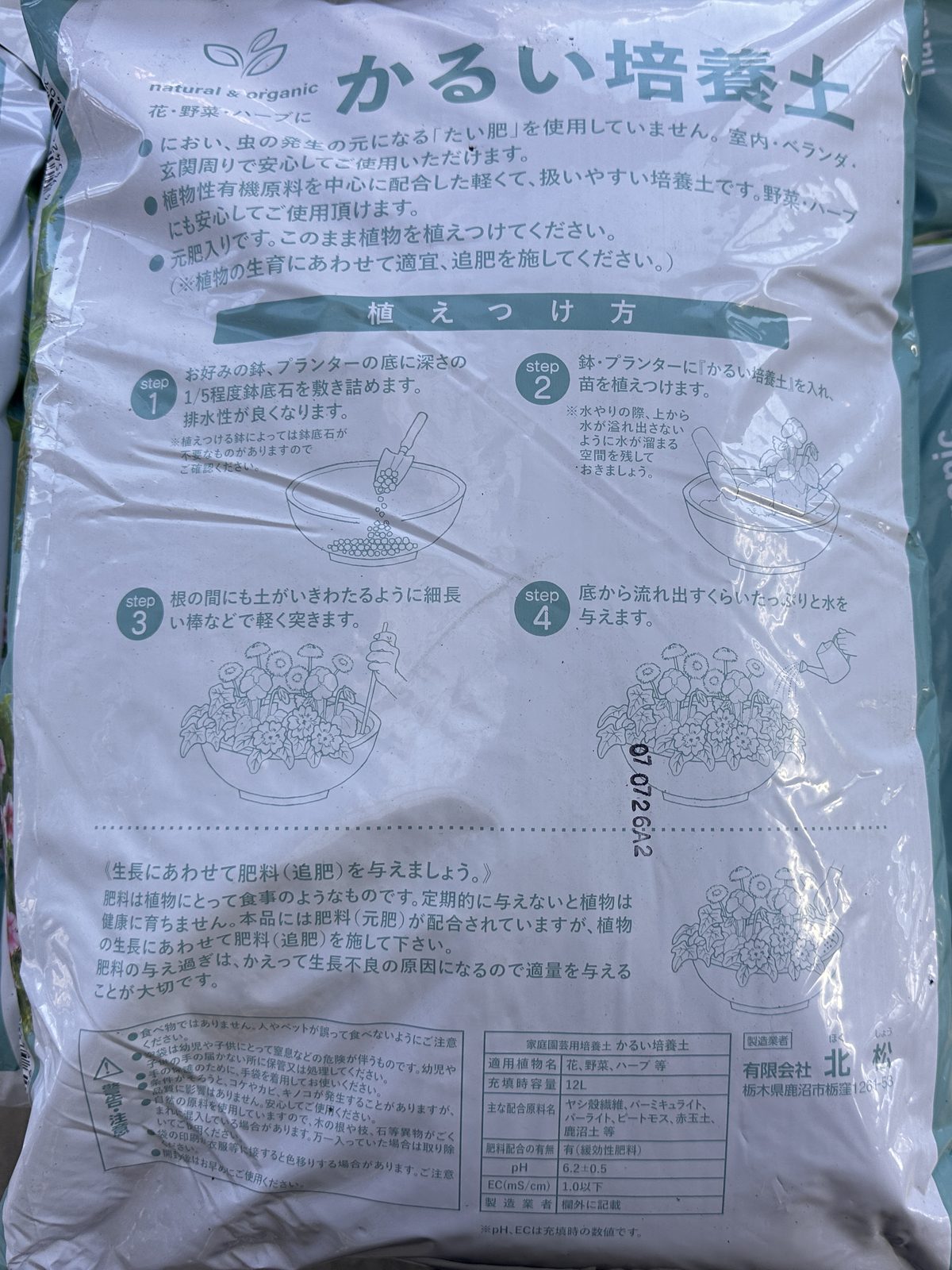 「かるい培養土」12L の袋の裏。上に「元肥入りです」などの説明文、植えつけ方の手順4つ、下に適用植物名・主な配合原料名・肥料配合の有無などを書いた表示欄