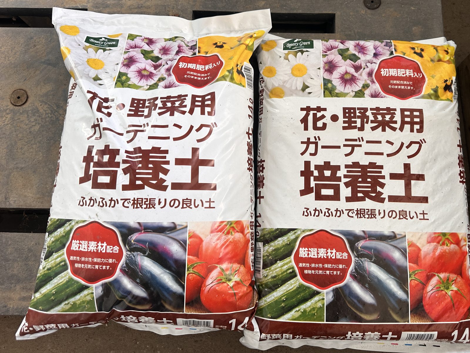 コメリの店頭に並ぶ Breezy Green 花・野菜用ガーデニング培養土 14L の袋2つ。表に「初期肥料入り」「ふかふかで根張りの良い土」とある